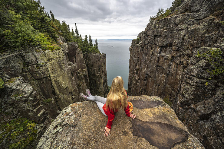 Girl sitting at the edge of a cliff