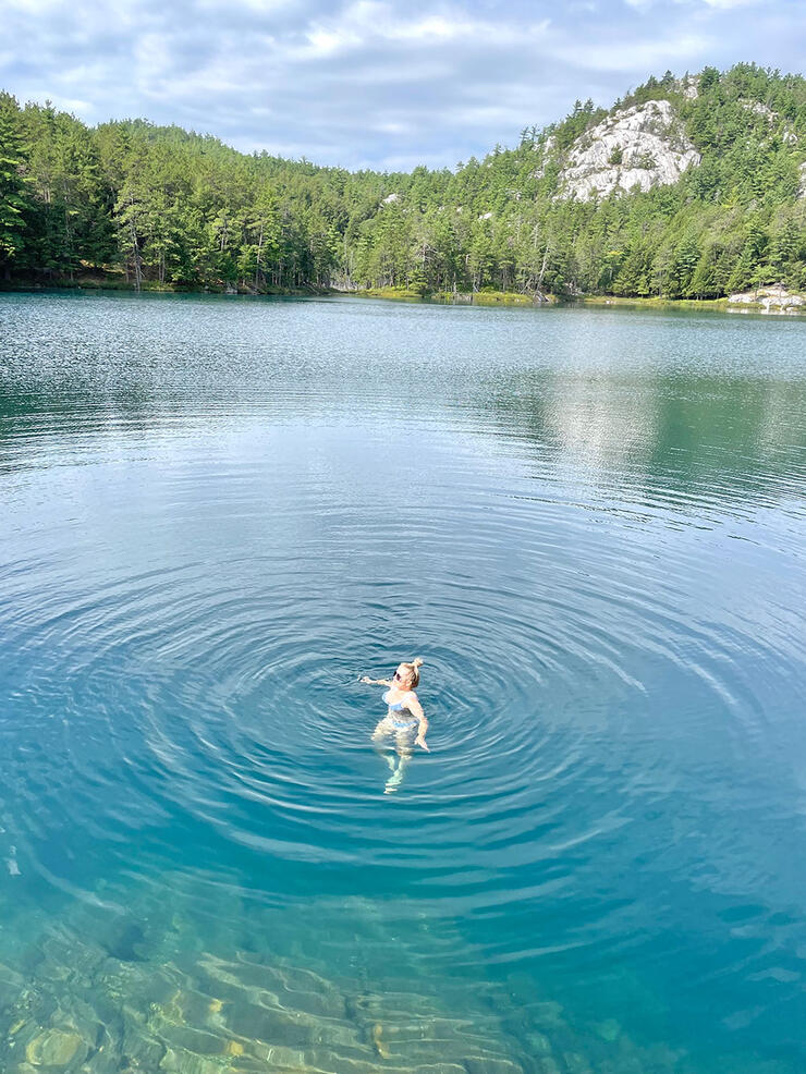 Swimmer floating at Topaz Lake in Killarney Provincial Park