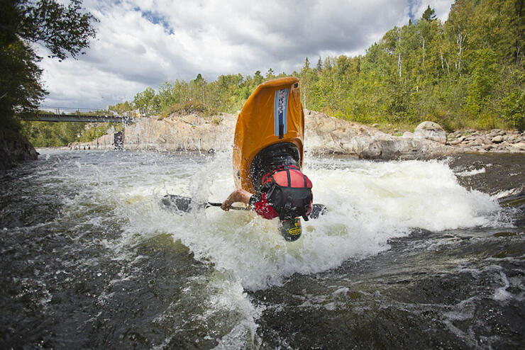 Person in whitewater kayak doing a flip