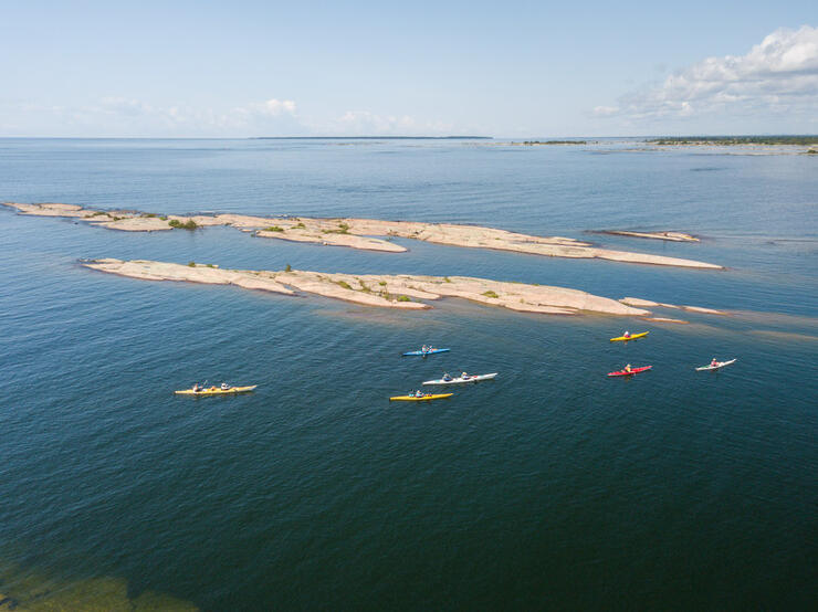 Overhead shot of kayaks paddling next to rocky islands.