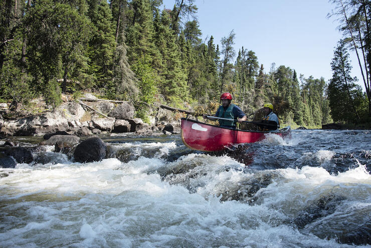 Canoe going over rapids