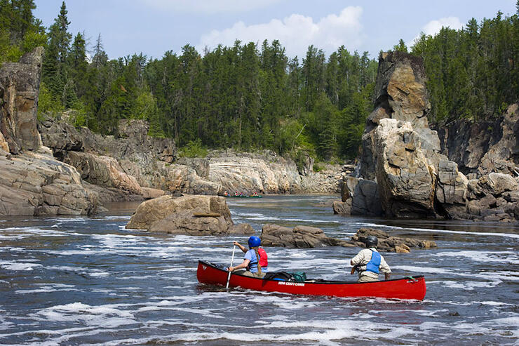 Two people wearing whitewater paddling gear in a canoe.