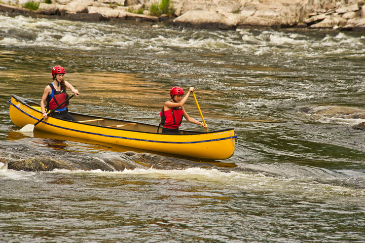 Two whitewater paddlers in a canoe