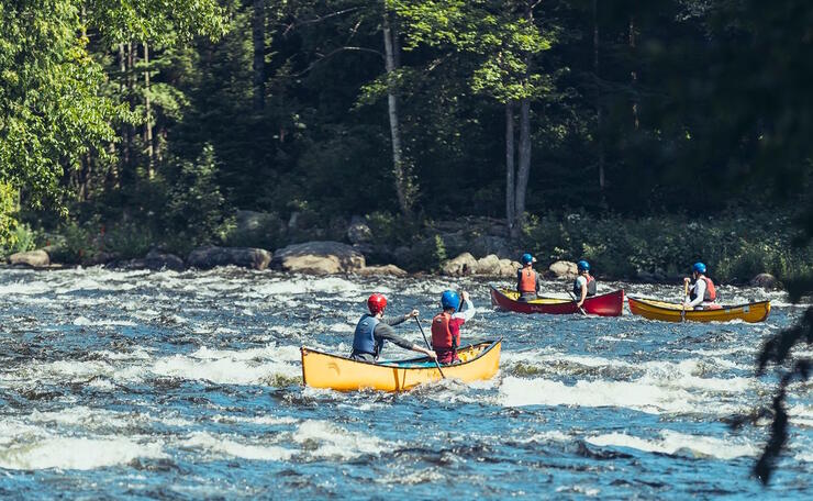 People in canoes going down rapids.