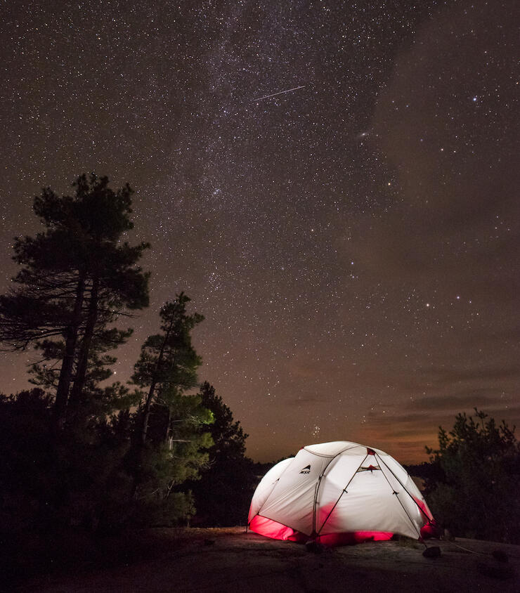 Tent at night with sky full of stars.