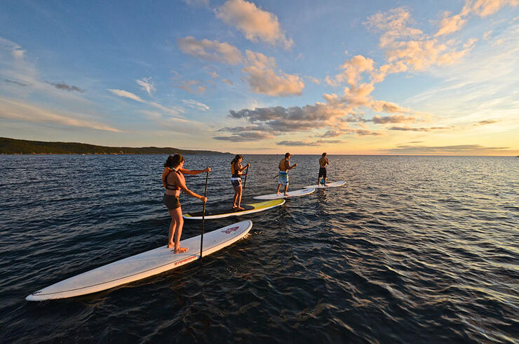 Group of paddle boarders at sunset