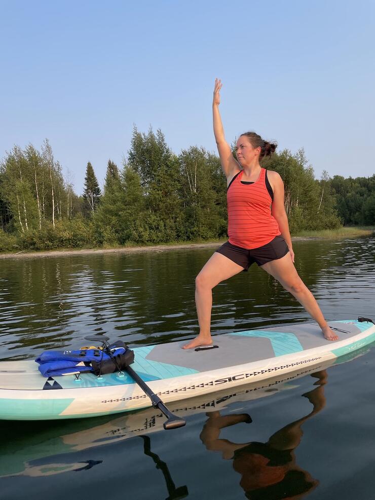 Woman participates in paddleboard yoga