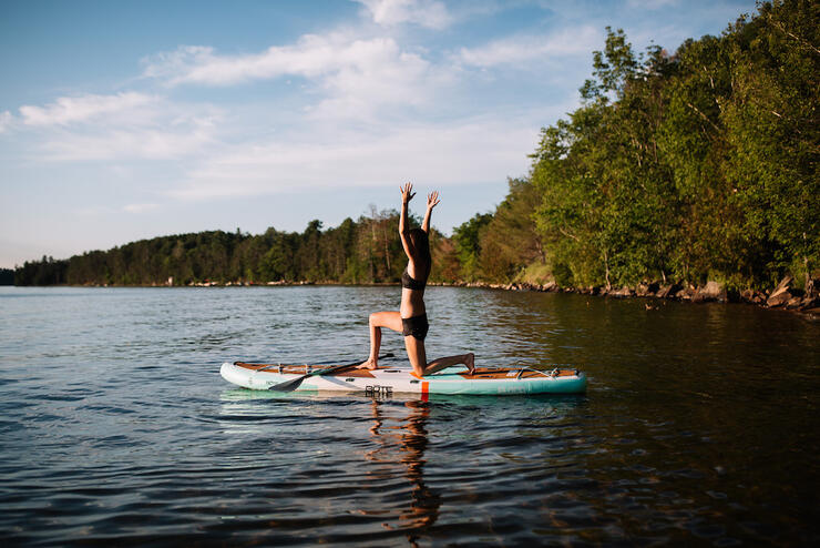 Women doing warrior pose on a sup