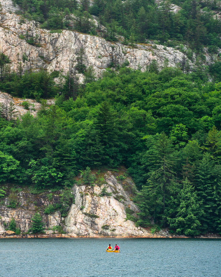 Canoe next to granite cliffs.