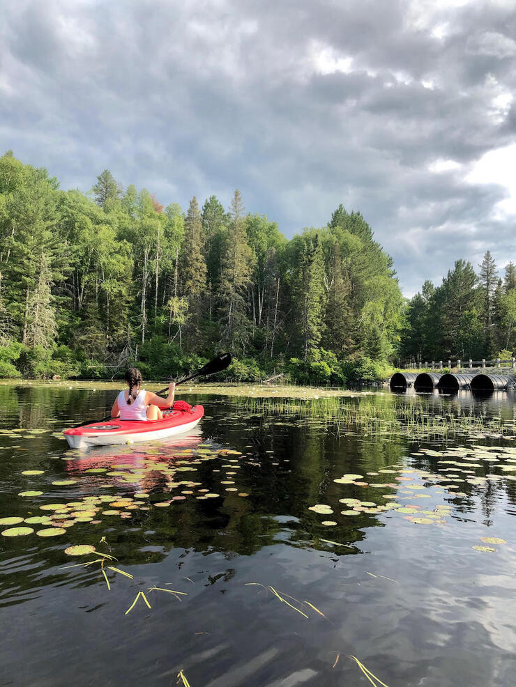 Woman on red kayak on a lake.