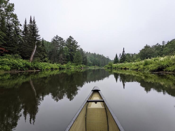 Bow of canoe on river.