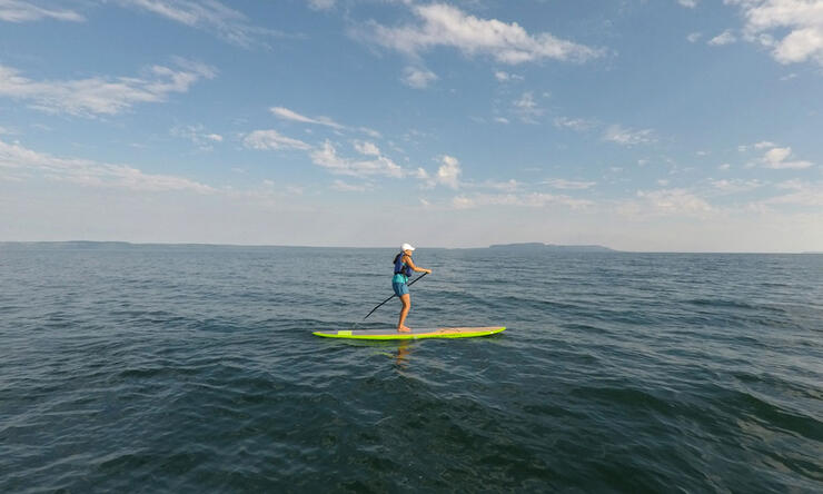 Woman on a standup paddleboard on big lake