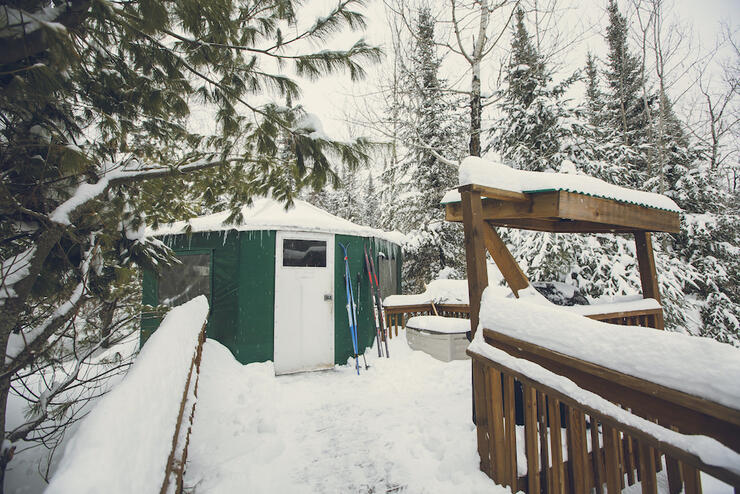 Green vinyl yurt in snowy forest setting