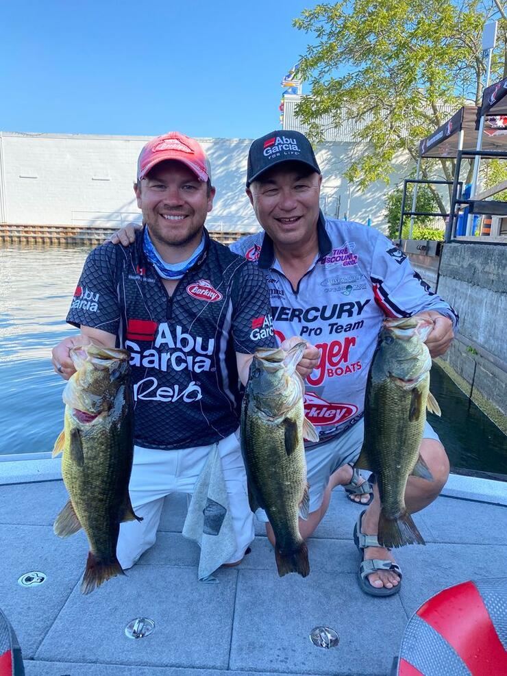 two anglers holding bass