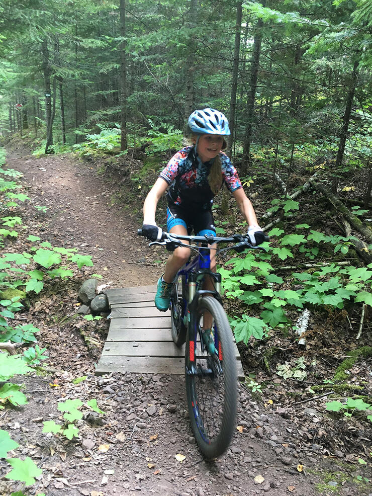 girl rides mountain bike on Thunder Bay forest trail