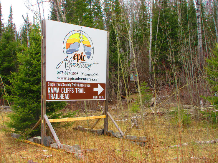 A large sign at the side of Highway 17 directs hikers to the trail head of Kama Cliffs Trail.