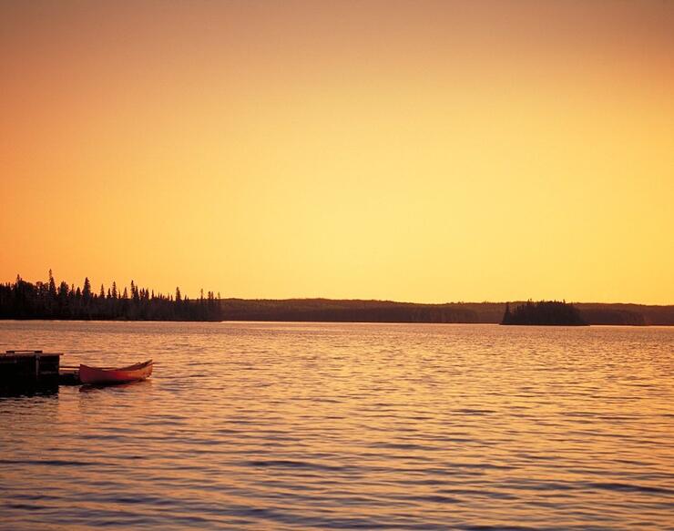 Canoe on lake at sunset
