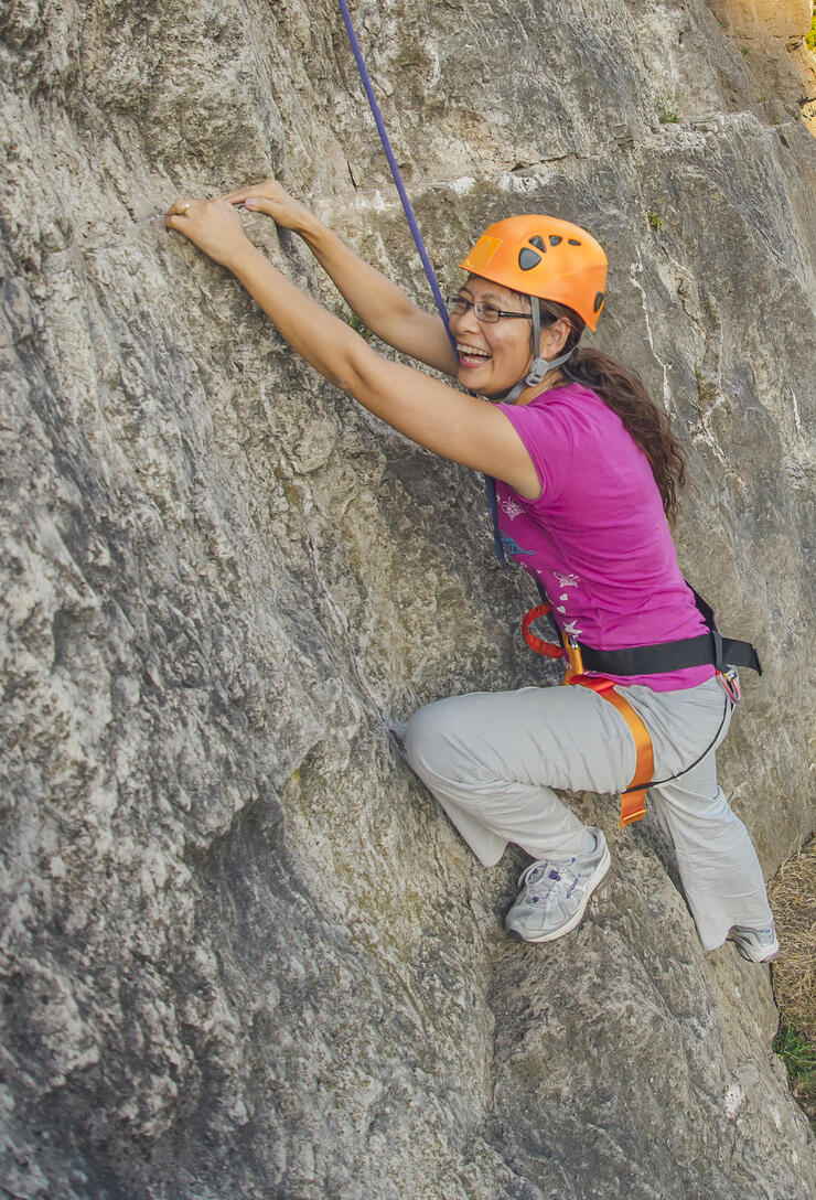Woman with big smile rock climbing