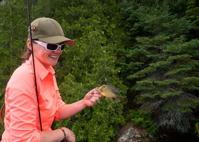 woman angler holding small ontario bass