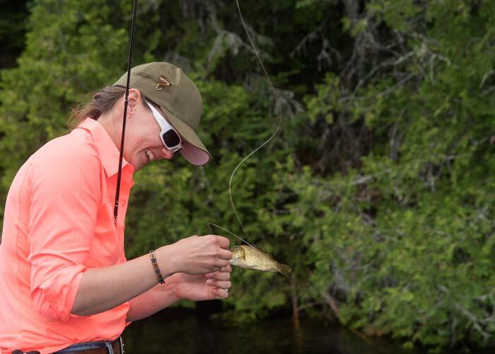 woman angler holding small ontario bass