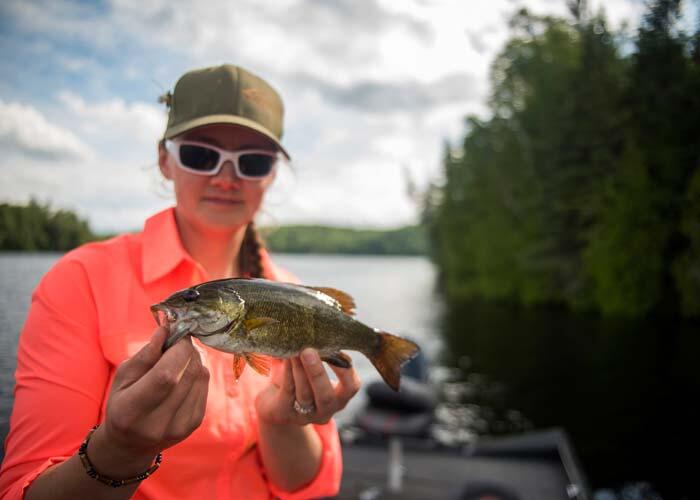 woman angler holding small ontario bass