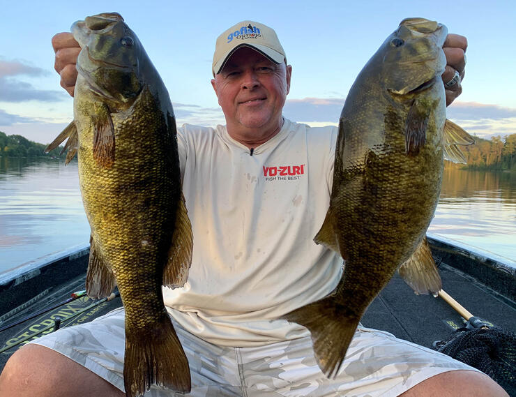 angler holding 2 bass