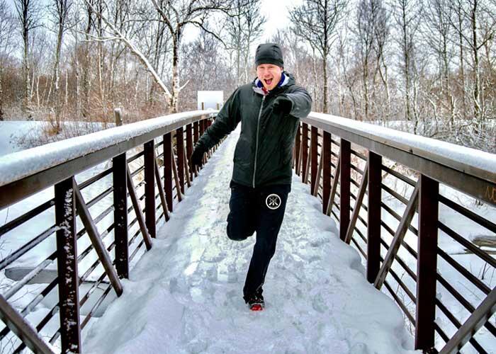man running in winter on bridge