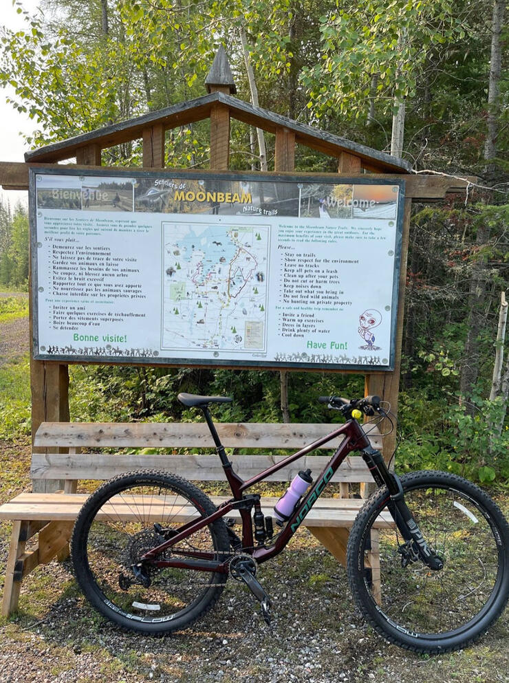 bike parked by trailhead and sign for Moonbeam Nature Trails