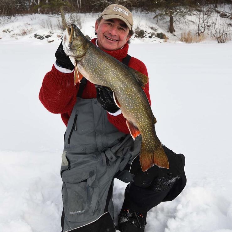 ice angler holding lake trout