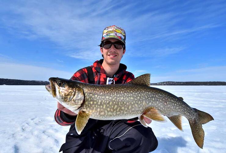 angler ice fishing lake trout