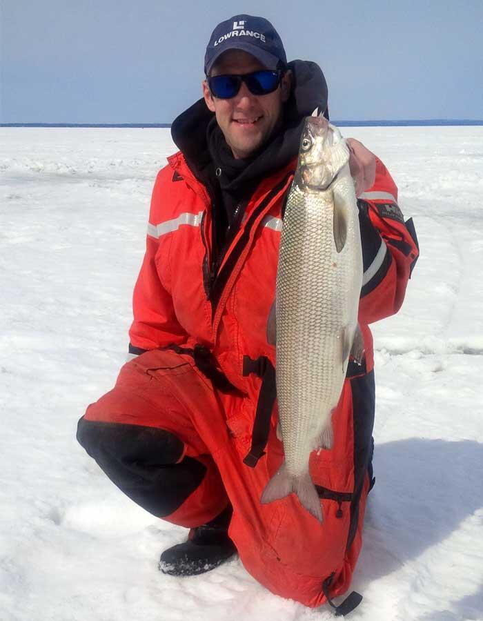 ice angler holding ontario whitefish