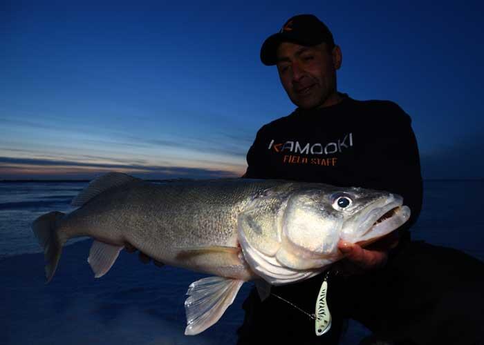 ice angler holding walleye