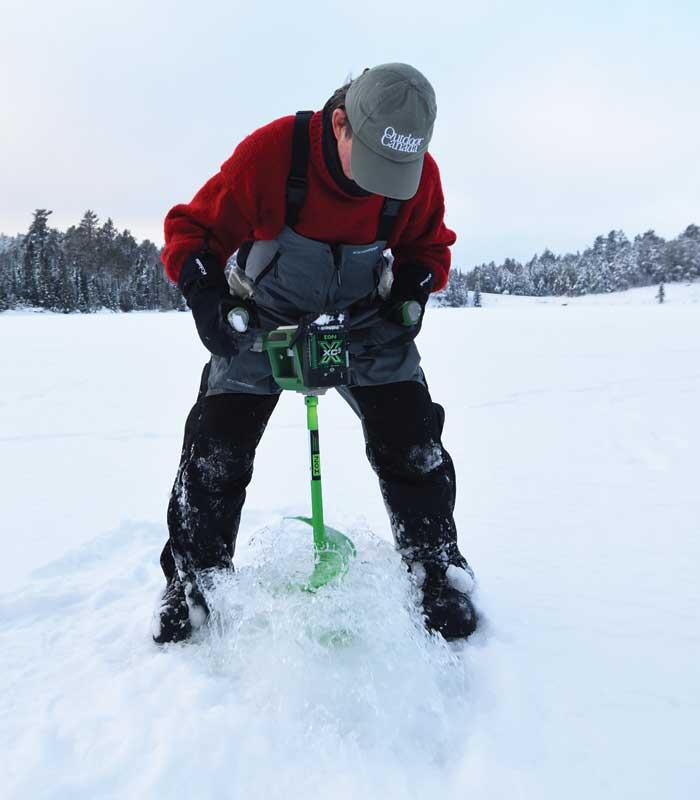 ice angler drilling hole in ice