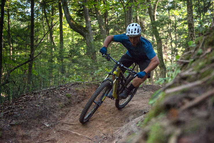 Man riding a mountain bike on a dirt trail in the forest