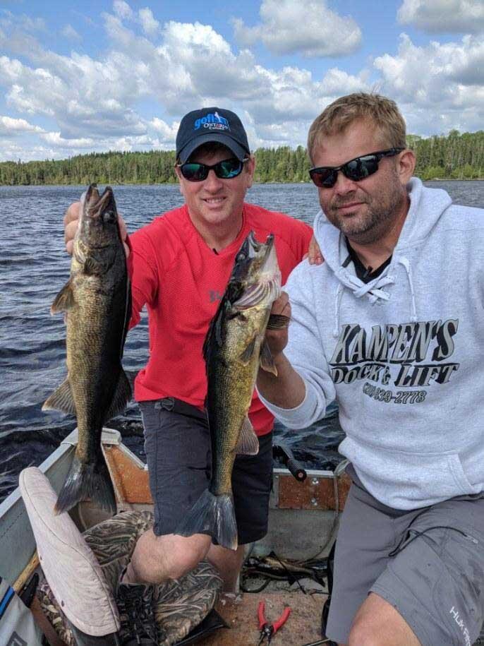 2 anglers holding walleye
