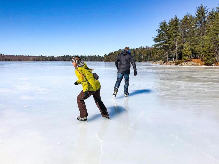 Two people skating on a lake