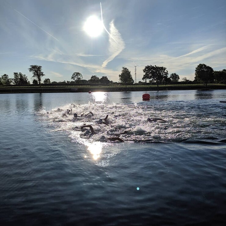Large group of swimmers racing in a lake. 