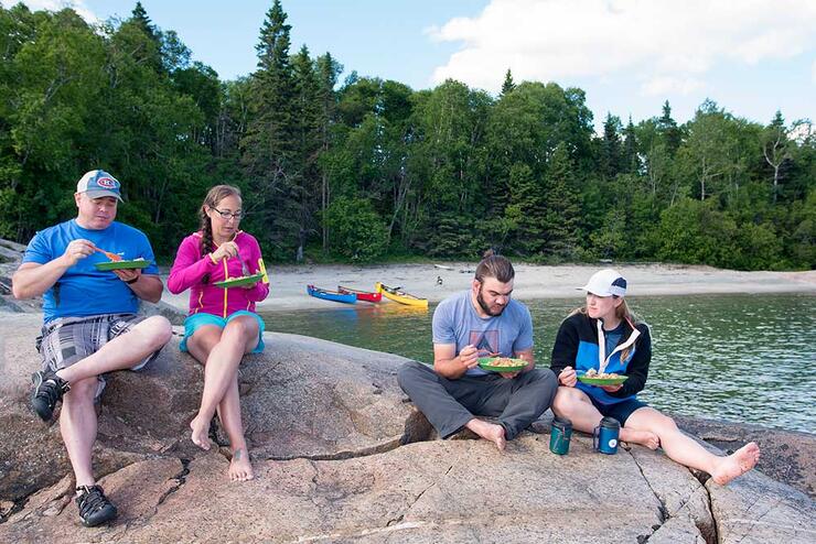 two couples eating food on camping  trip