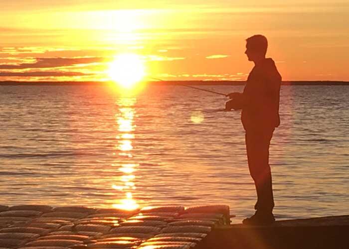 angler fishing at sunset