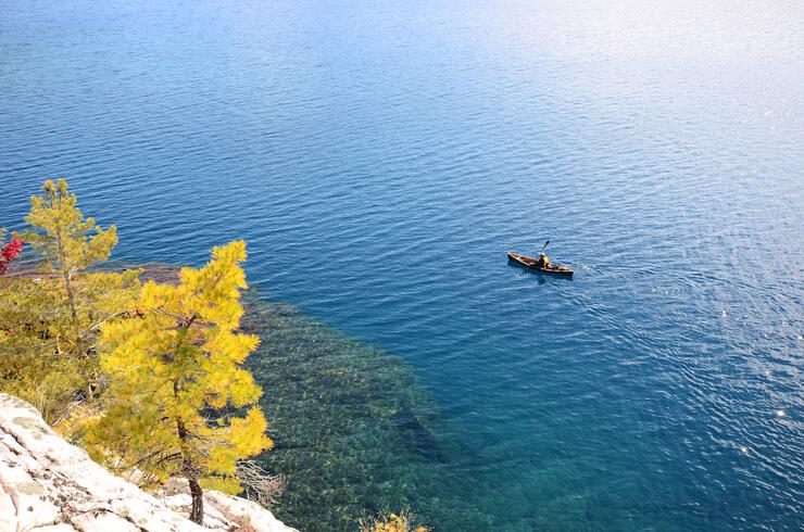 aerial view of canoeist paddling on turquoise lake 