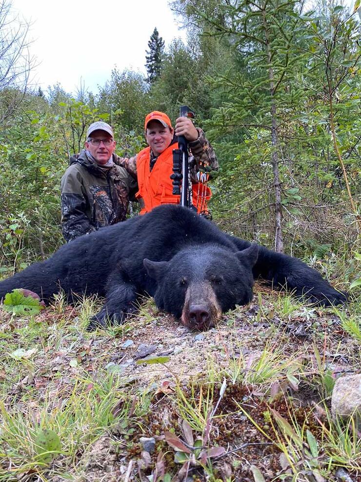 2 hunters with dispatched black bear