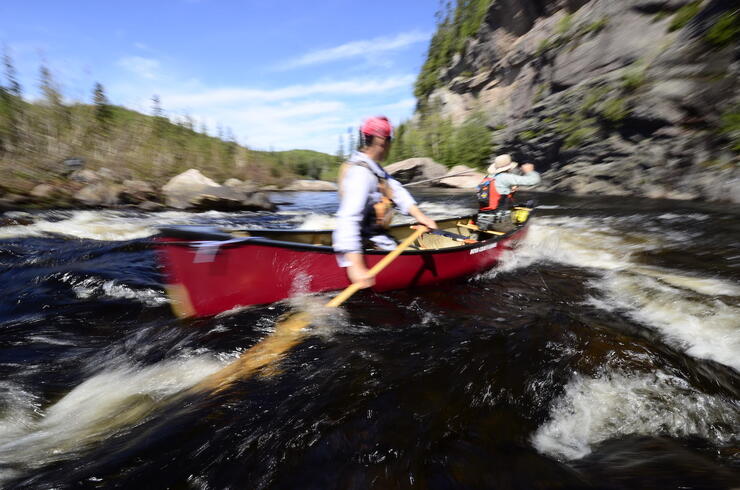 two paddlers in red canoe in whitewater 