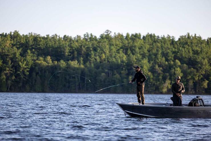 anglers fly fishing in boat on lake