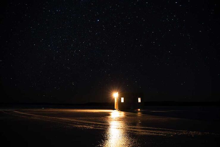 ice hut on lake starry sky
