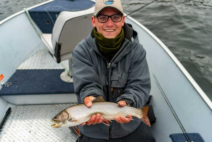 angler fishing trout from boat