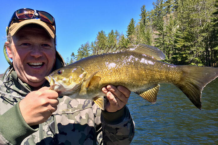 angler holding ontario smallmouth bass